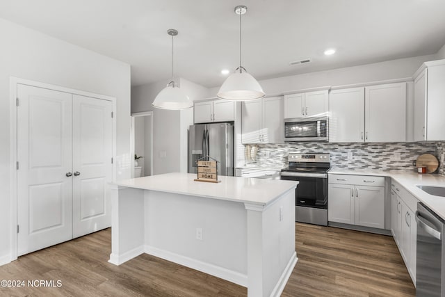 kitchen featuring stainless steel appliances, dark wood-type flooring, backsplash, and a center island