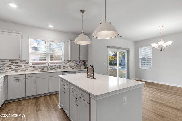 kitchen featuring tasteful backsplash, light countertops, a sink, and light wood-style flooring