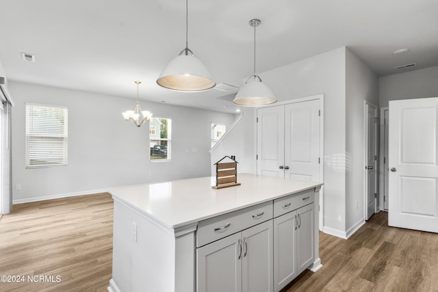 kitchen with plenty of natural light, light wood-type flooring, a kitchen island, and visible vents