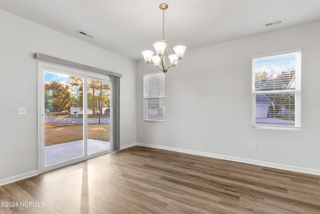 unfurnished dining area with wood finished floors, visible vents, and a healthy amount of sunlight