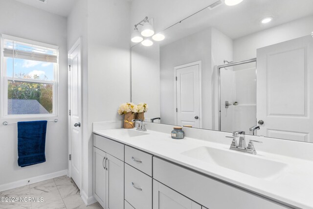 full bath with marble finish floor, a sink, visible vents, and a shower stall