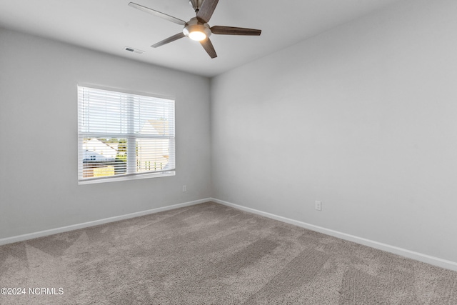 spare room featuring carpet, visible vents, and baseboards