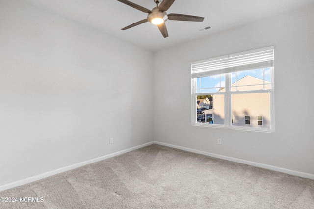 empty room featuring carpet floors, visible vents, ceiling fan, and baseboards