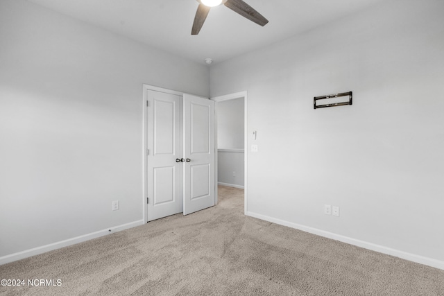 unfurnished bedroom featuring carpet, a closet, ceiling fan, and baseboards