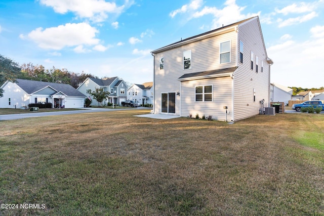 back of property with a residential view, cooling unit, and a yard