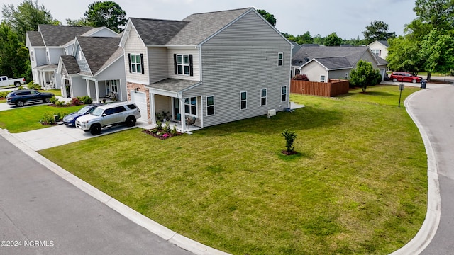 view of front of home featuring concrete driveway, a residential view, an attached garage, fence, and a front lawn