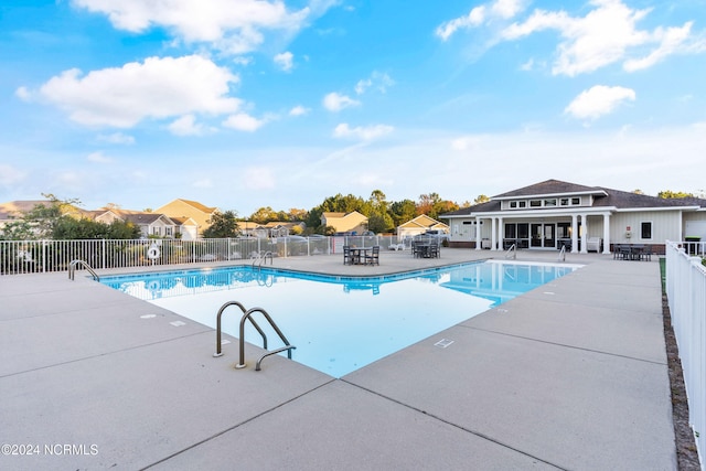 pool featuring fence and a patio