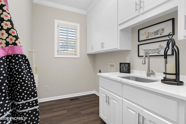 washroom with cabinets, hookup for a washing machine, dark wood-type flooring, crown molding, and sink