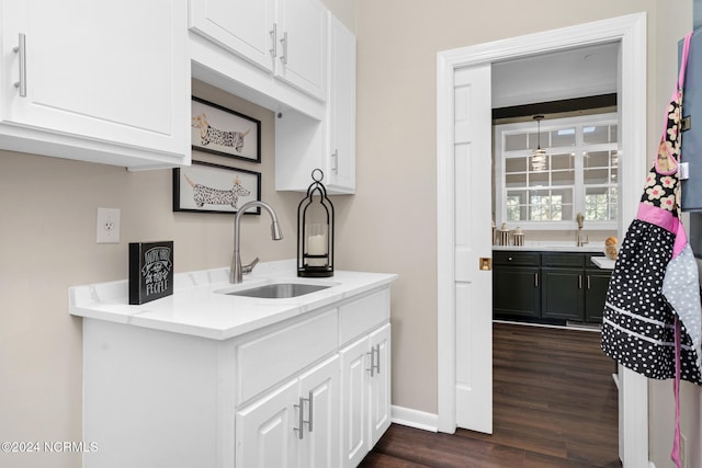 kitchen with white cabinets, light stone countertops, sink, and dark wood-type flooring