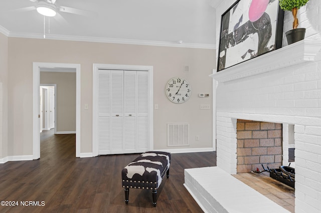 living area with ornamental molding, a fireplace, dark hardwood / wood-style floors, and ceiling fan