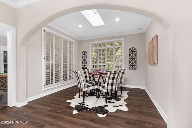 dining room featuring crown molding, dark hardwood / wood-style floors, and a skylight