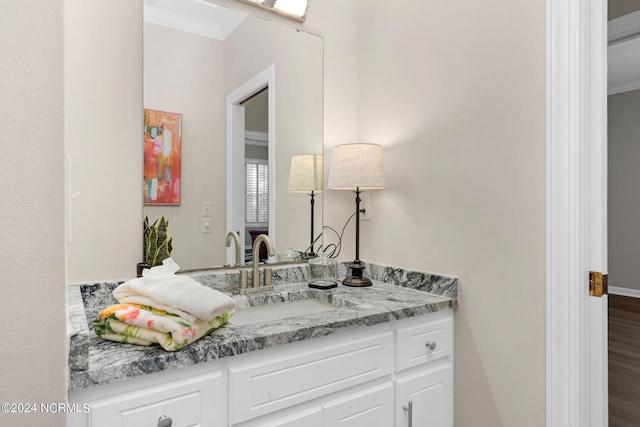 bathroom featuring vanity, ornamental molding, and wood-type flooring