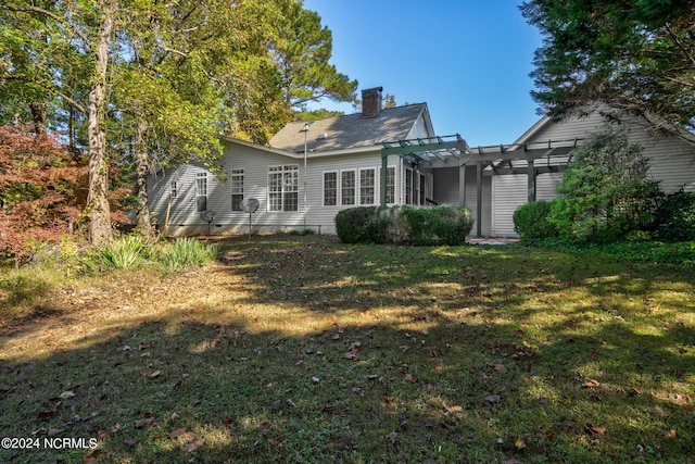 rear view of house with a yard and a pergola