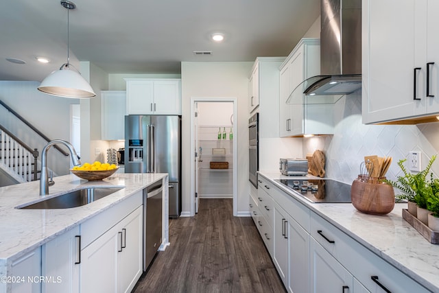 kitchen featuring tasteful backsplash, stainless steel appliances, pendant lighting, dark hardwood / wood-style flooring, and wall chimney range hood