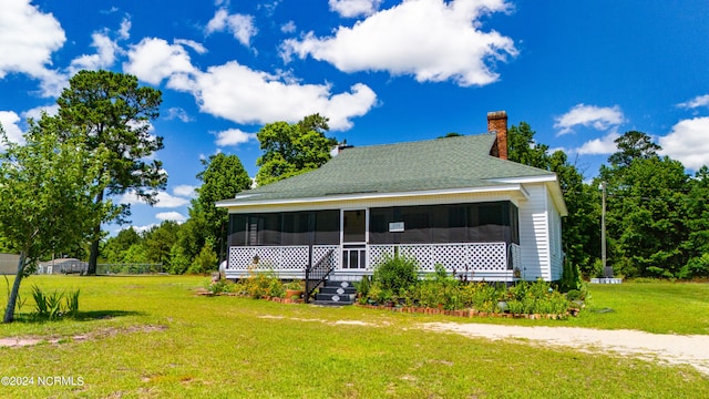 back of house with a yard and a sunroom