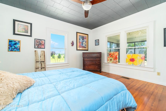 bedroom with hardwood / wood-style flooring, multiple windows, and ceiling fan