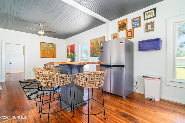 kitchen with a healthy amount of sunlight, stainless steel refrigerator, and wood-type flooring