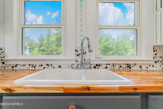 bathroom featuring sink, a wealth of natural light, and a bath to relax in