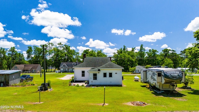 back of property with a storage unit and a lawn