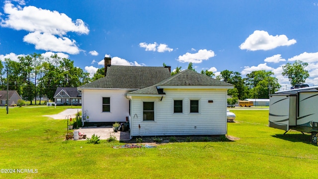 back of property with a patio area and a lawn