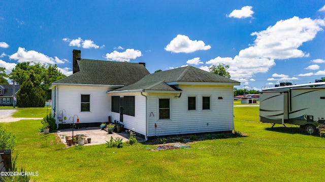 rear view of property with a patio and a yard