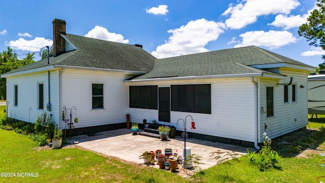 rear view of property featuring a patio, a sunroom, and a yard