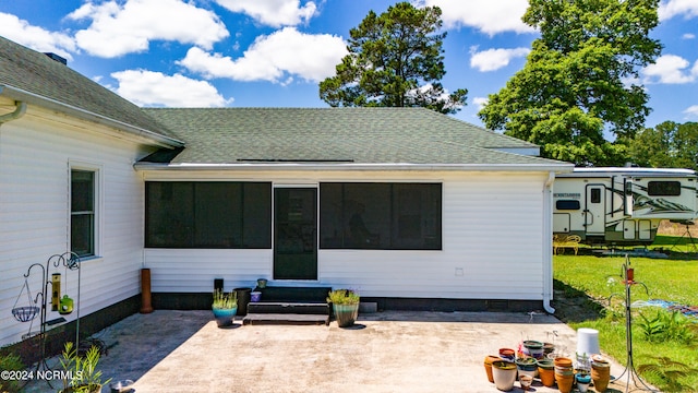 rear view of property with a sunroom, a patio area, and a yard