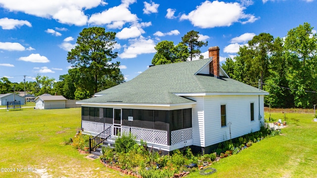 view of side of home featuring a yard and a sunroom