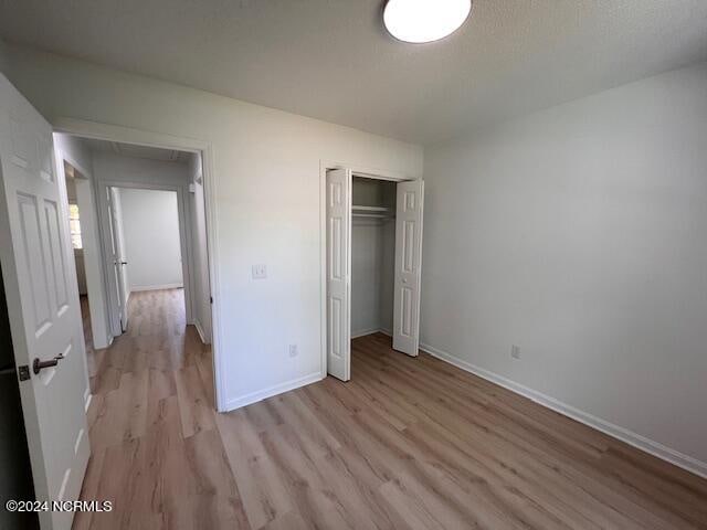 unfurnished bedroom featuring a closet and light wood-type flooring