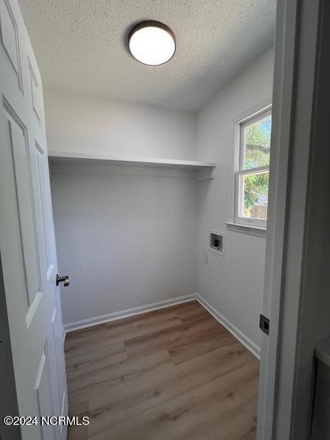 interior space featuring a textured ceiling, washer hookup, and hardwood / wood-style floors