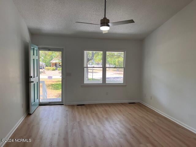 spare room featuring ceiling fan, hardwood / wood-style flooring, and a textured ceiling