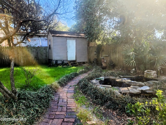 view of yard with an outbuilding, a shed, and a fenced backyard