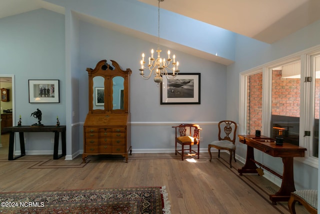 living area with a notable chandelier, vaulted ceiling, and wood-type flooring