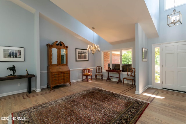 entryway featuring high vaulted ceiling, a notable chandelier, and hardwood / wood-style floors