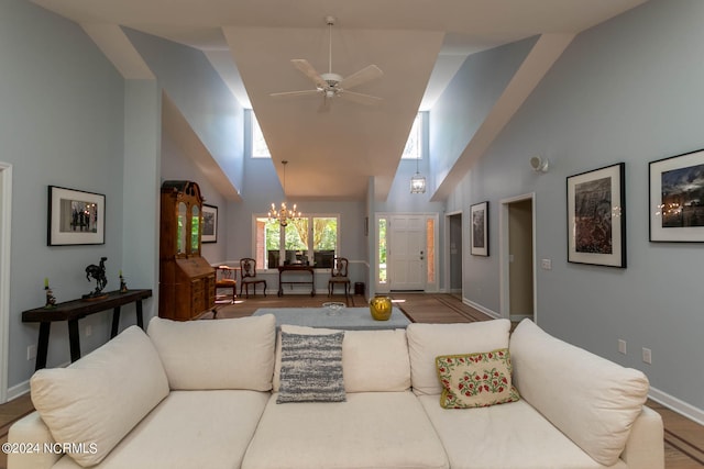 living room featuring high vaulted ceiling, ceiling fan with notable chandelier, and hardwood / wood-style floors