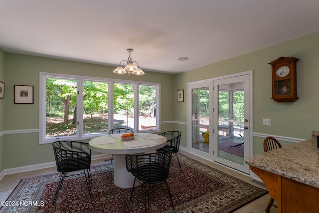 tiled dining room with a wealth of natural light and an inviting chandelier