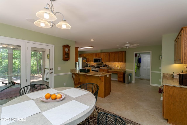 dining room with ceiling fan with notable chandelier and light tile floors