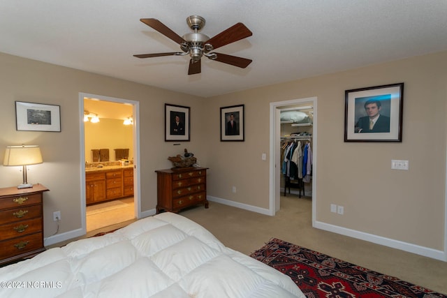 carpeted bedroom featuring ceiling fan, ensuite bathroom, a closet, and a spacious closet