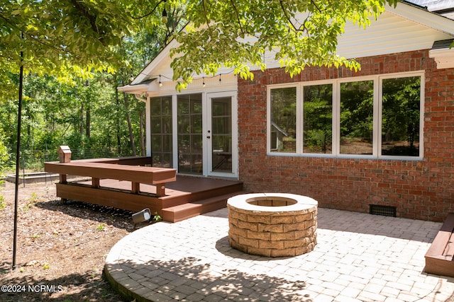 exterior space with an outdoor fire pit and a wooden deck