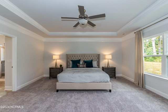 carpeted bedroom with ceiling fan, ornamental molding, and a tray ceiling