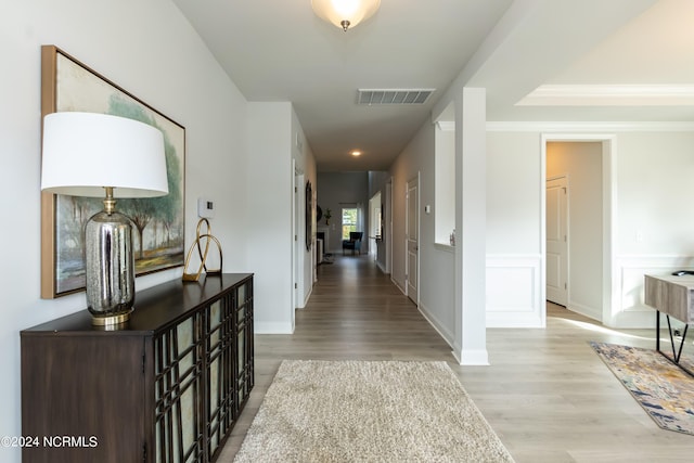 foyer entrance with hardwood / wood-style floors, a healthy amount of sunlight, and ornamental molding