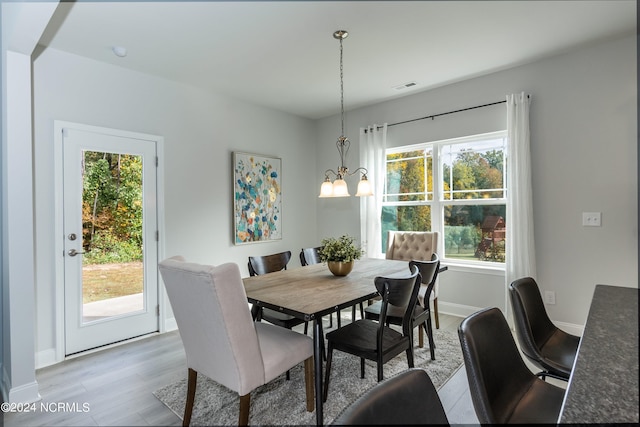 kitchen featuring white cabinetry, sink, stainless steel appliances, and decorative light fixtures