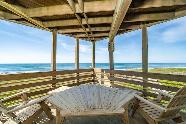 unfurnished sunroom with a water view and a beach view