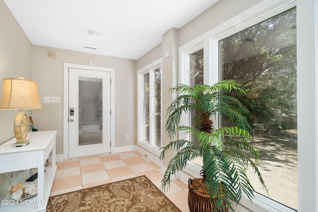 doorway to outside with light tile patterned floors