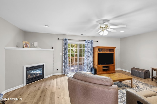 living room with light wood-type flooring and ceiling fan