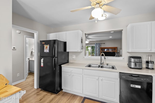 kitchen with white cabinets, black appliances, sink, and light wood-type flooring