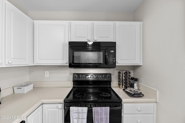 kitchen with black appliances and white cabinets