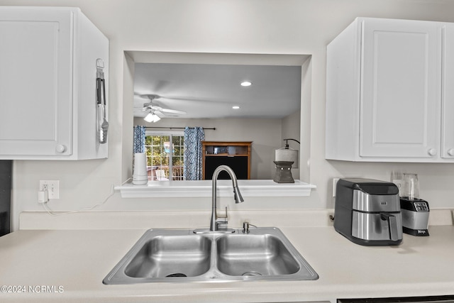 kitchen with white cabinetry, sink, and ceiling fan