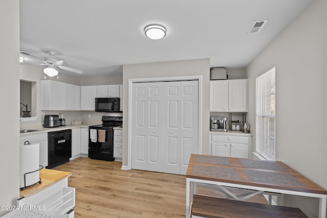 kitchen with black appliances, white cabinetry, light wood-type flooring, and ceiling fan