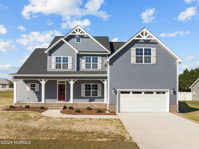 view of front of property featuring driveway, a garage, and a porch